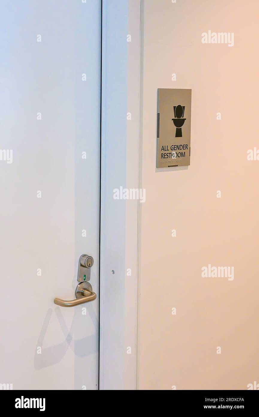 All gender restroom sign outside public restroom in college building Stock Photo