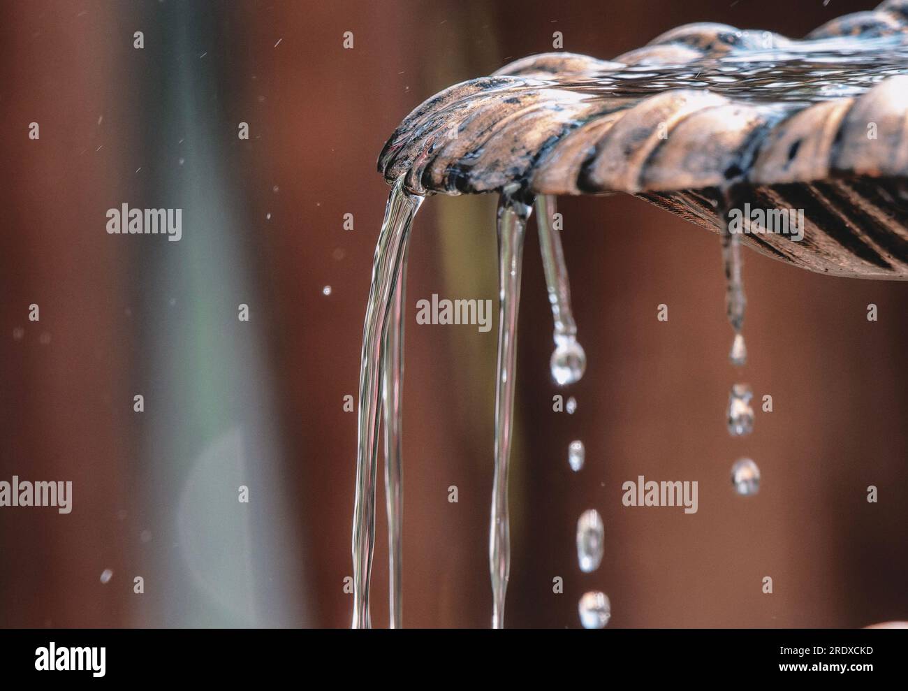 Fountain water pours over the rim Stock Photo