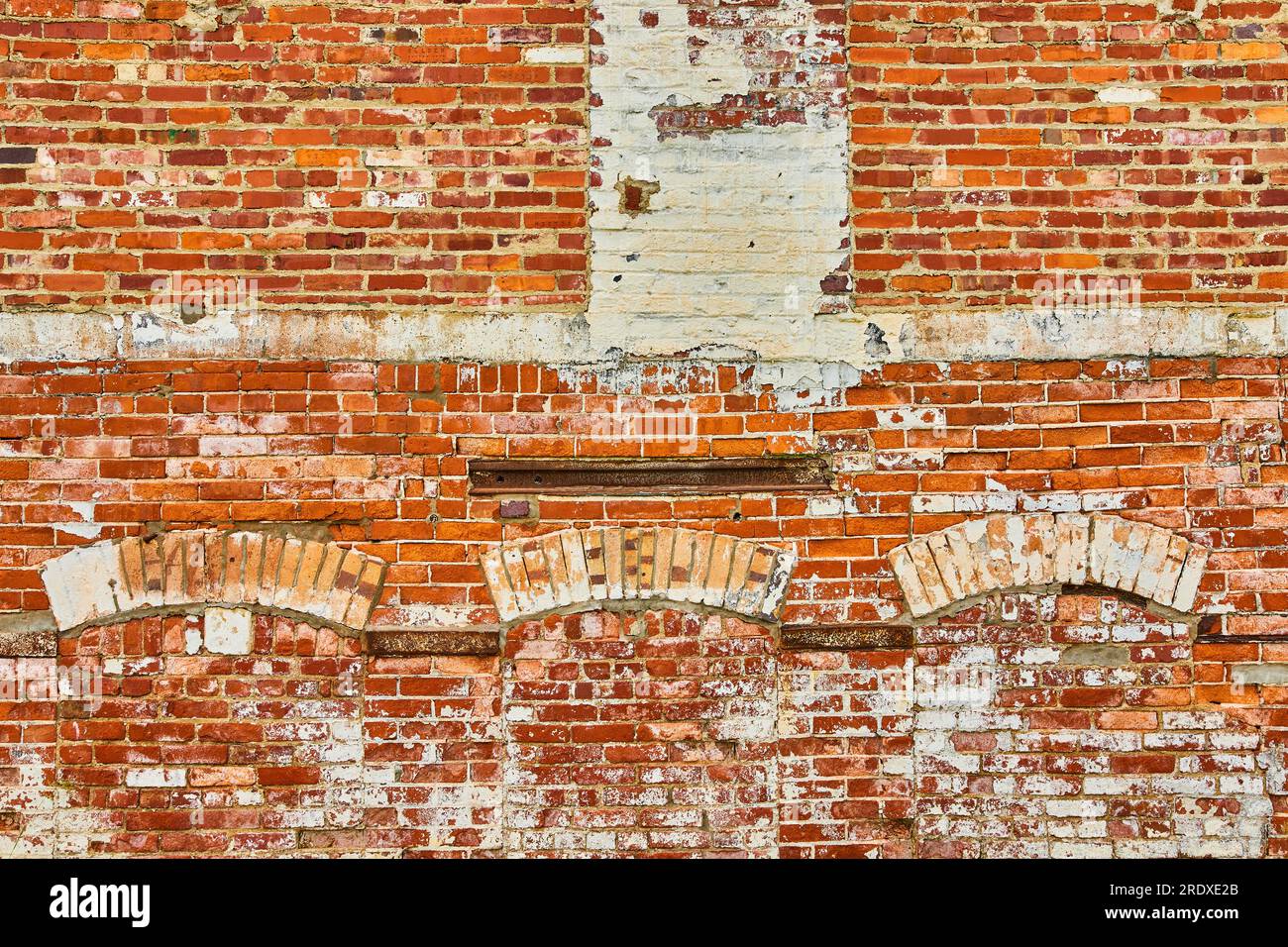 Wall of red bricks coated in white paint with filled in doorways and arches background asset
