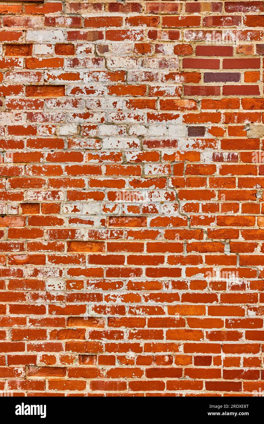 Orange and red brick wall with busted white bricks vertical background asset Stock Photo