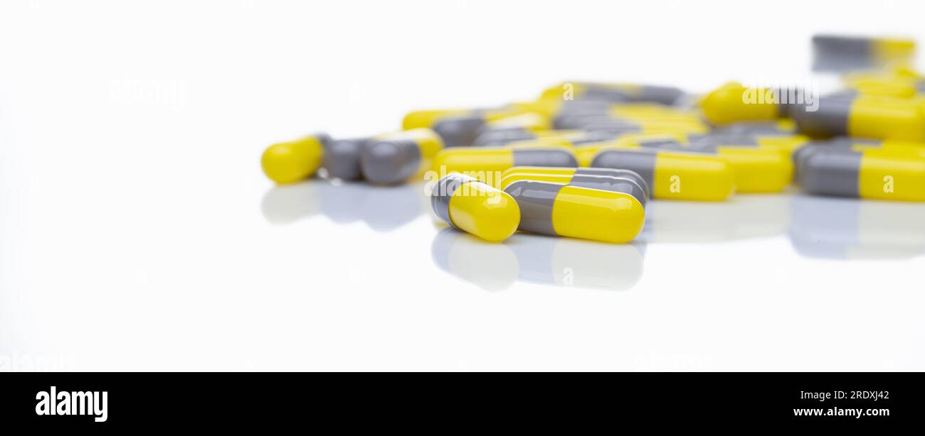 Yellow and gray probiotic capsule pill on white background
