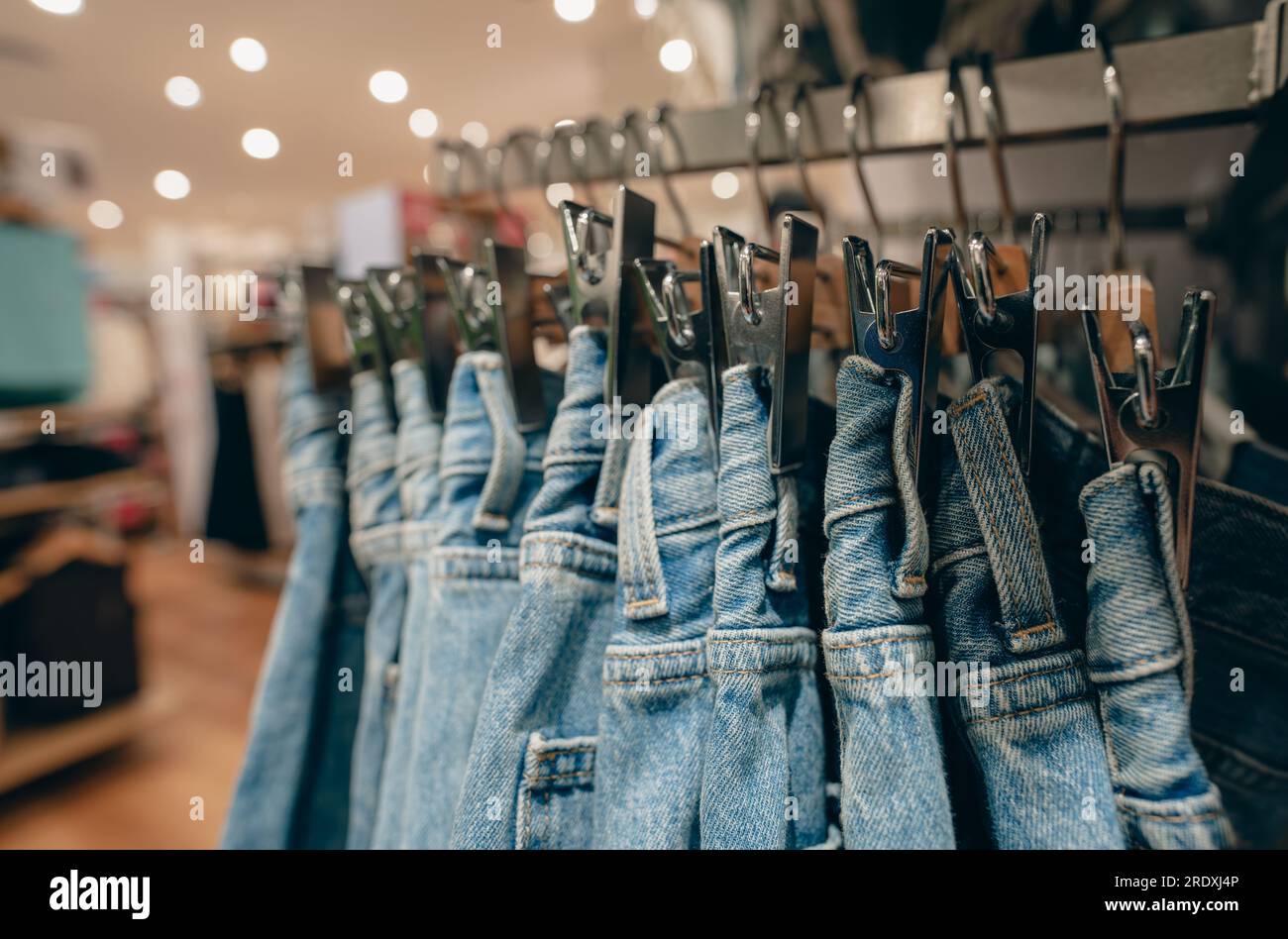 Denim pants in clothing store. Jeans on hanger hanging on rack in