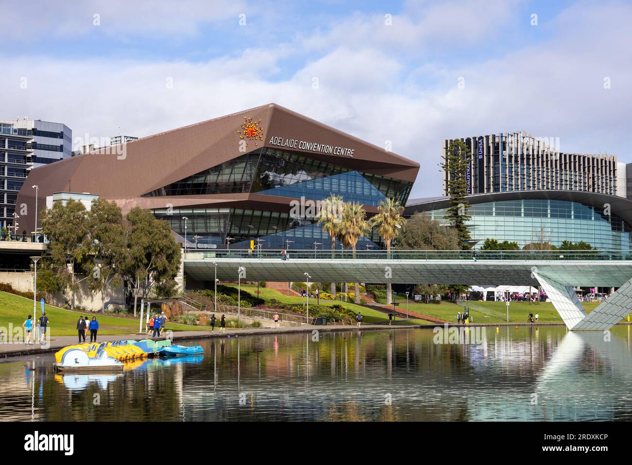 A landscape of the Adelaide cityscape and paddle boats on the River