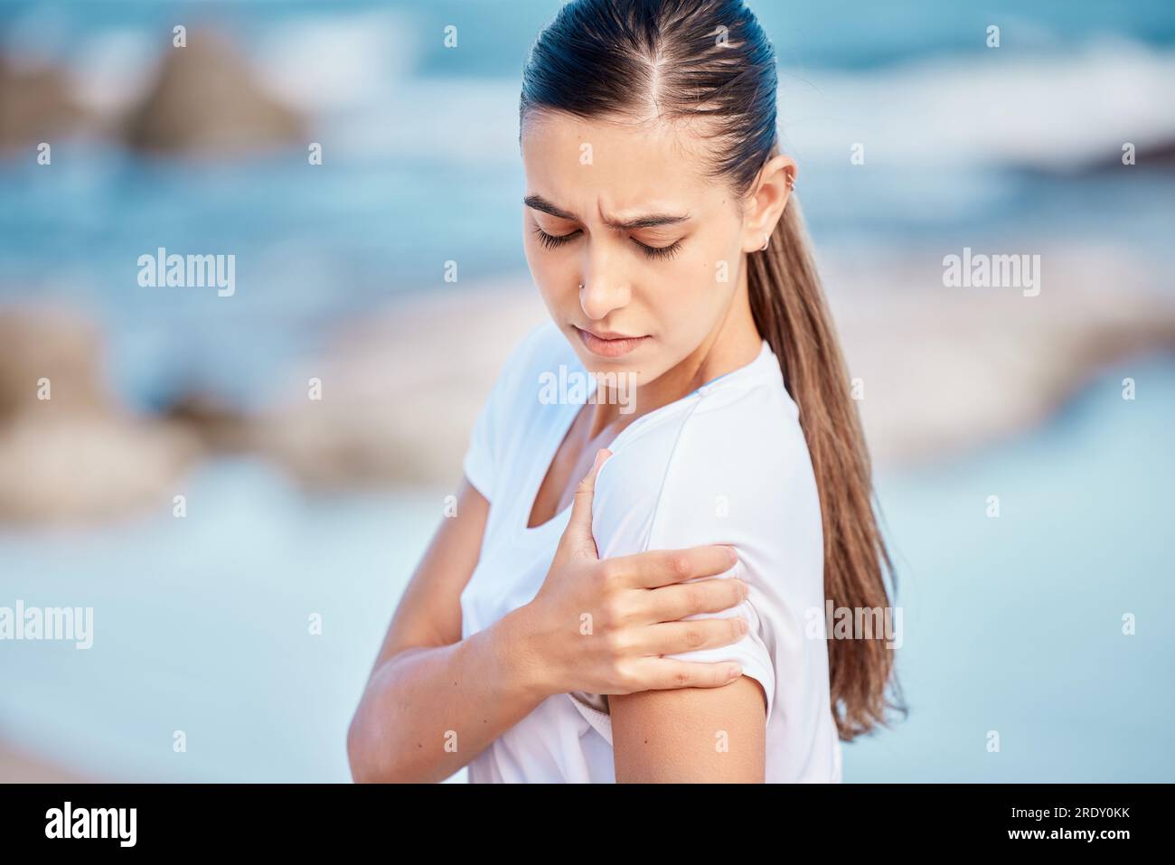 Woman, fitness and arm pain on beach from workout injury, exercise or outdoor accident. Female