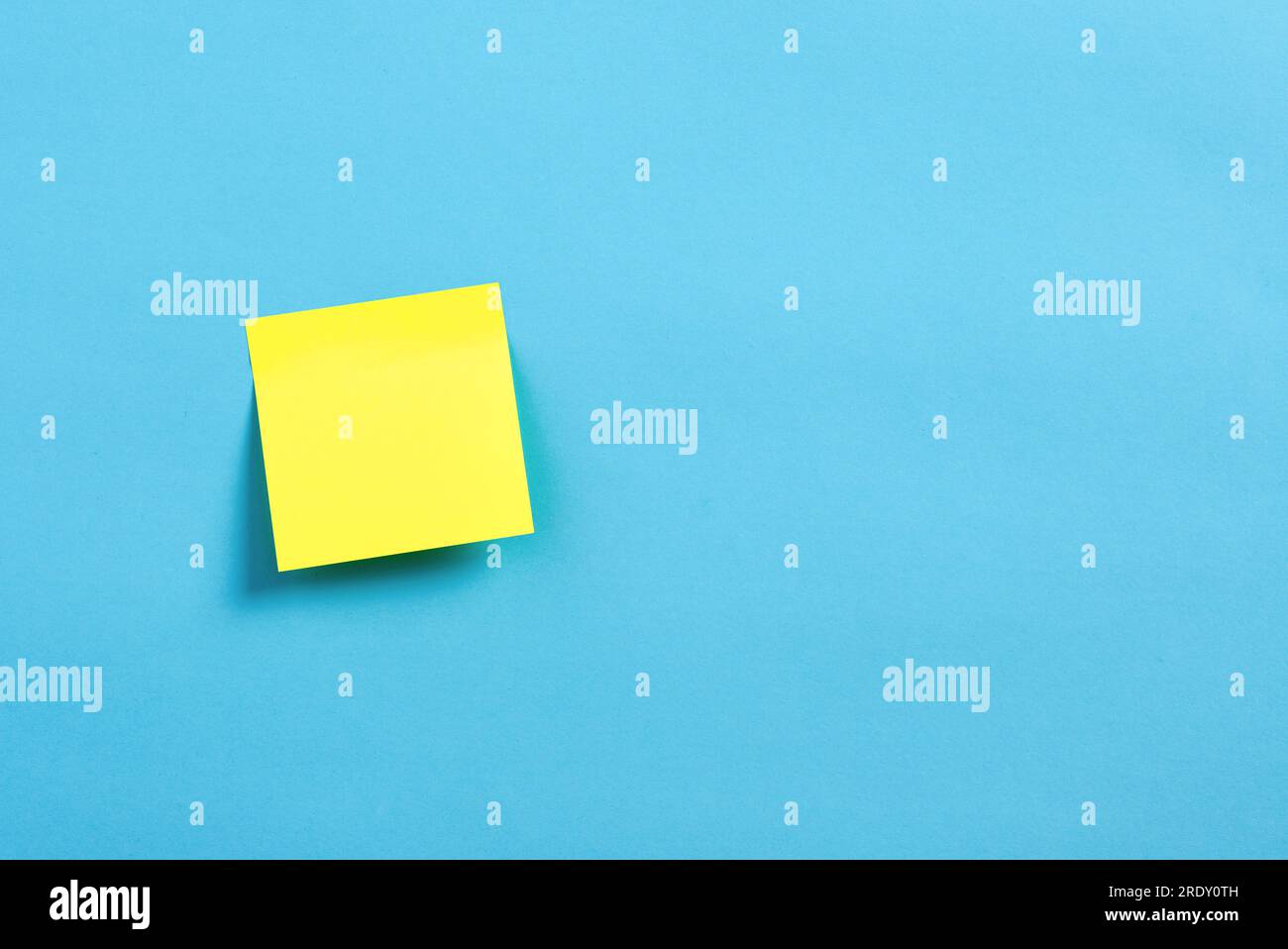 Blank or empty yellow sticky note paper on blue background. Stock Photo