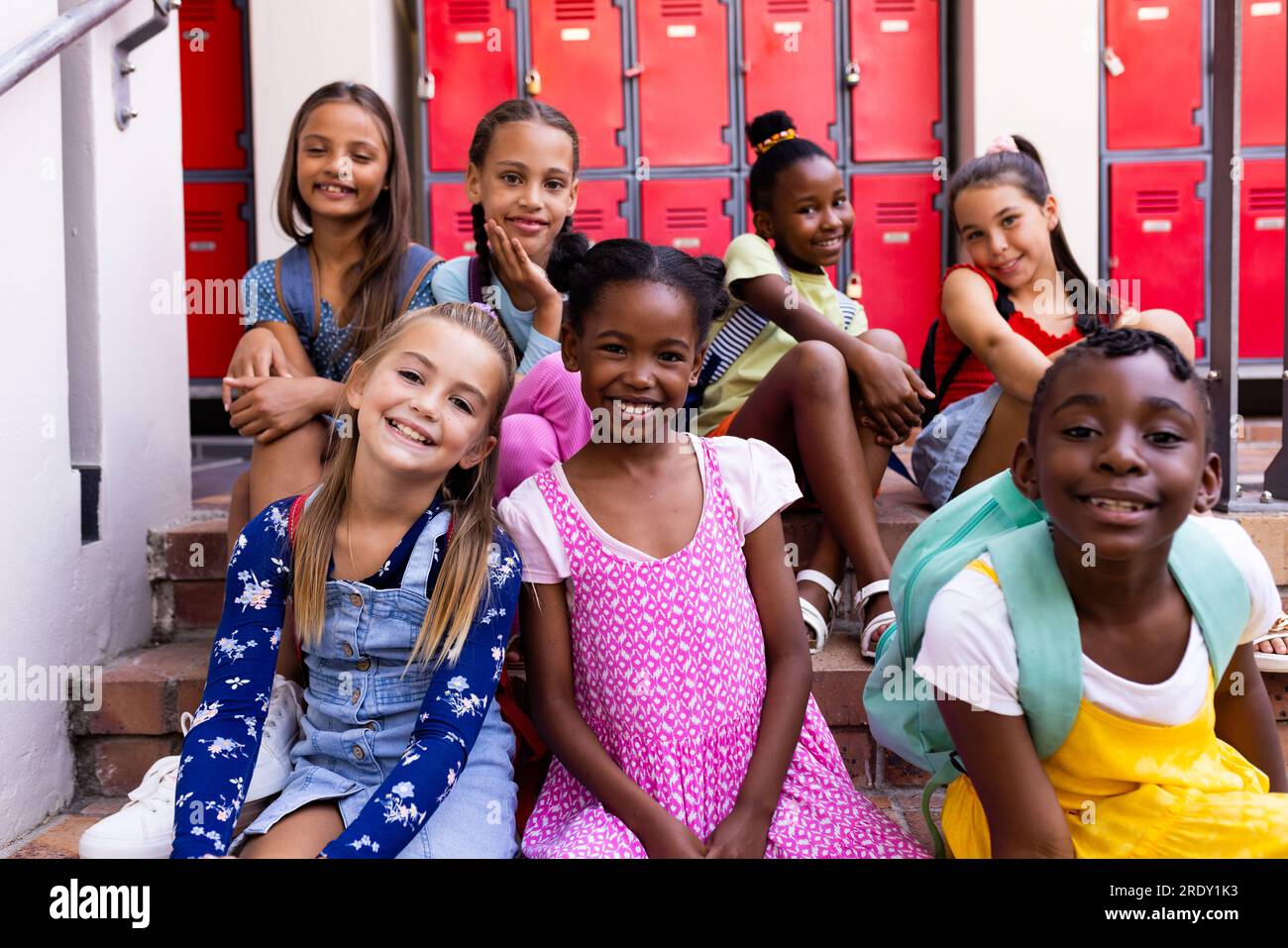 Portrait of diverse happy schoolgirls in elementary school cloakroom Stock Photo