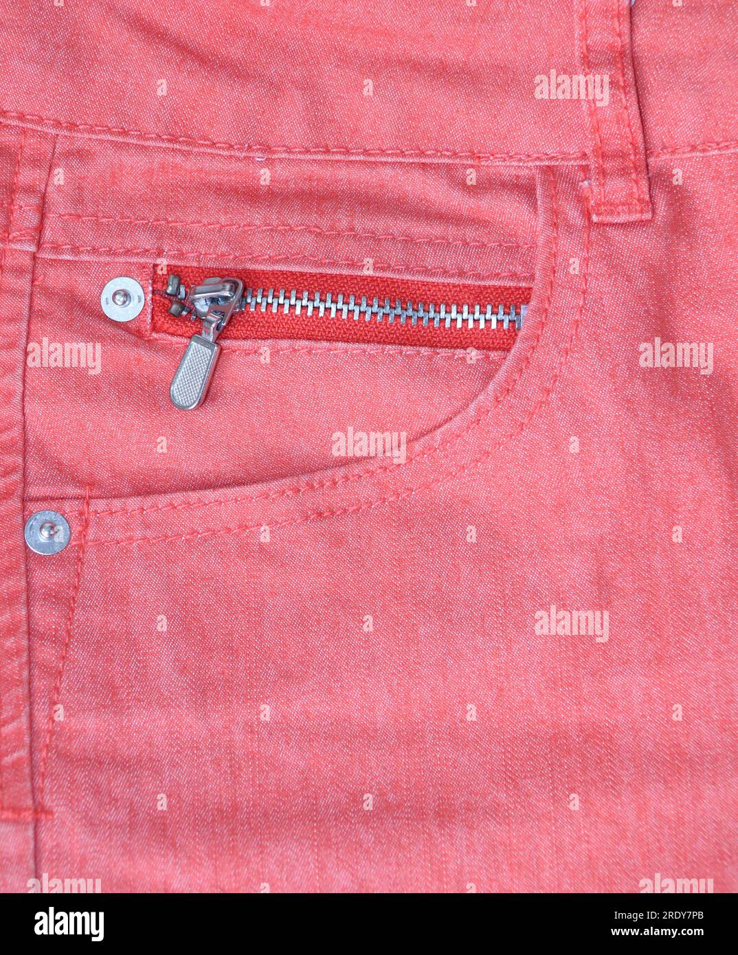 Jeans pocket of pink color. Vertical background with denim texture of coral color and pocket Stock Photo