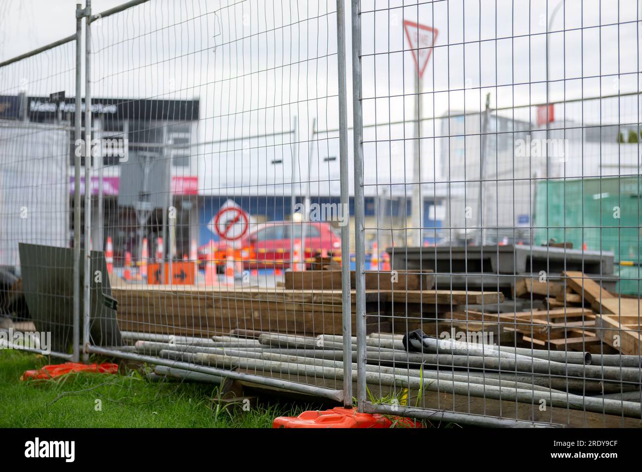 Construction materials protected by metal fence. Outoffocus traffic