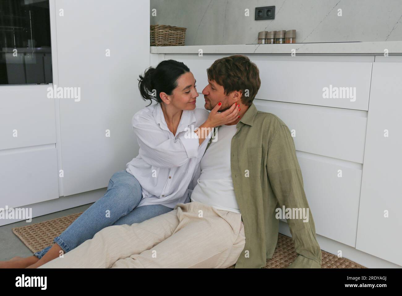 Romantic couple sitting in kitchen at home Stock Photo