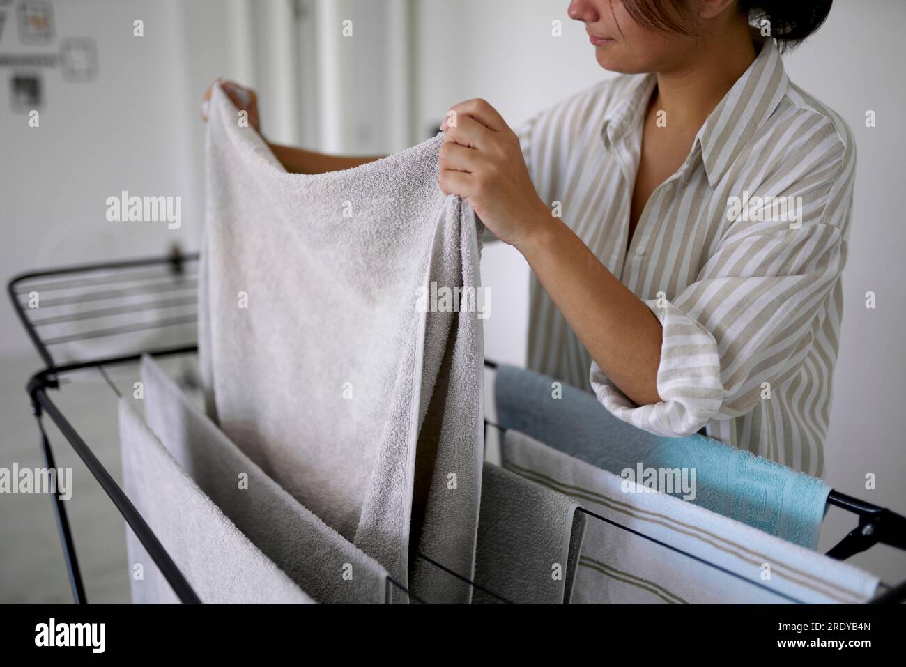 Woman removing dried clothes from rack Stock Photo