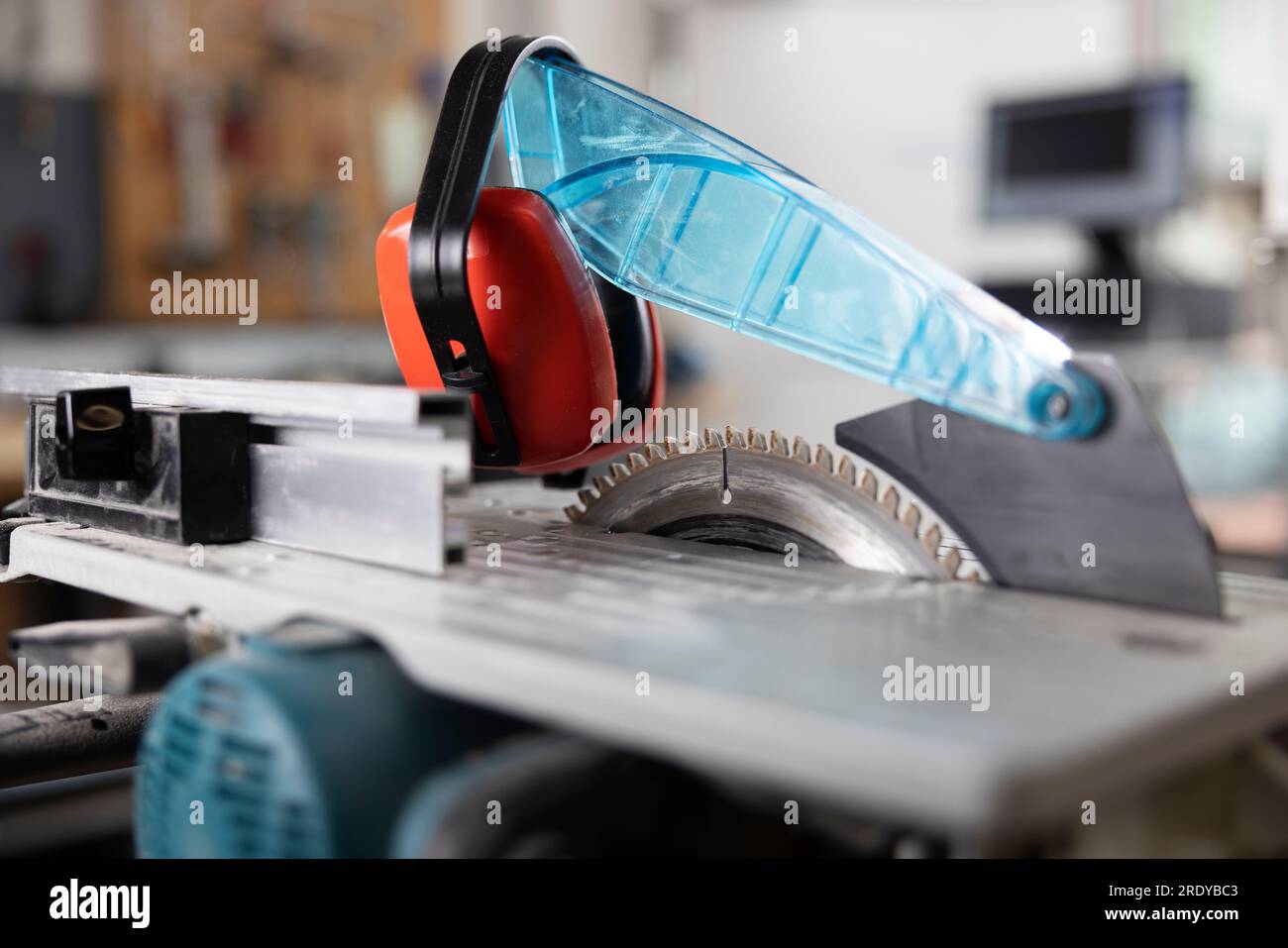 Circular saw with ear protectors in workshop Stock Photo