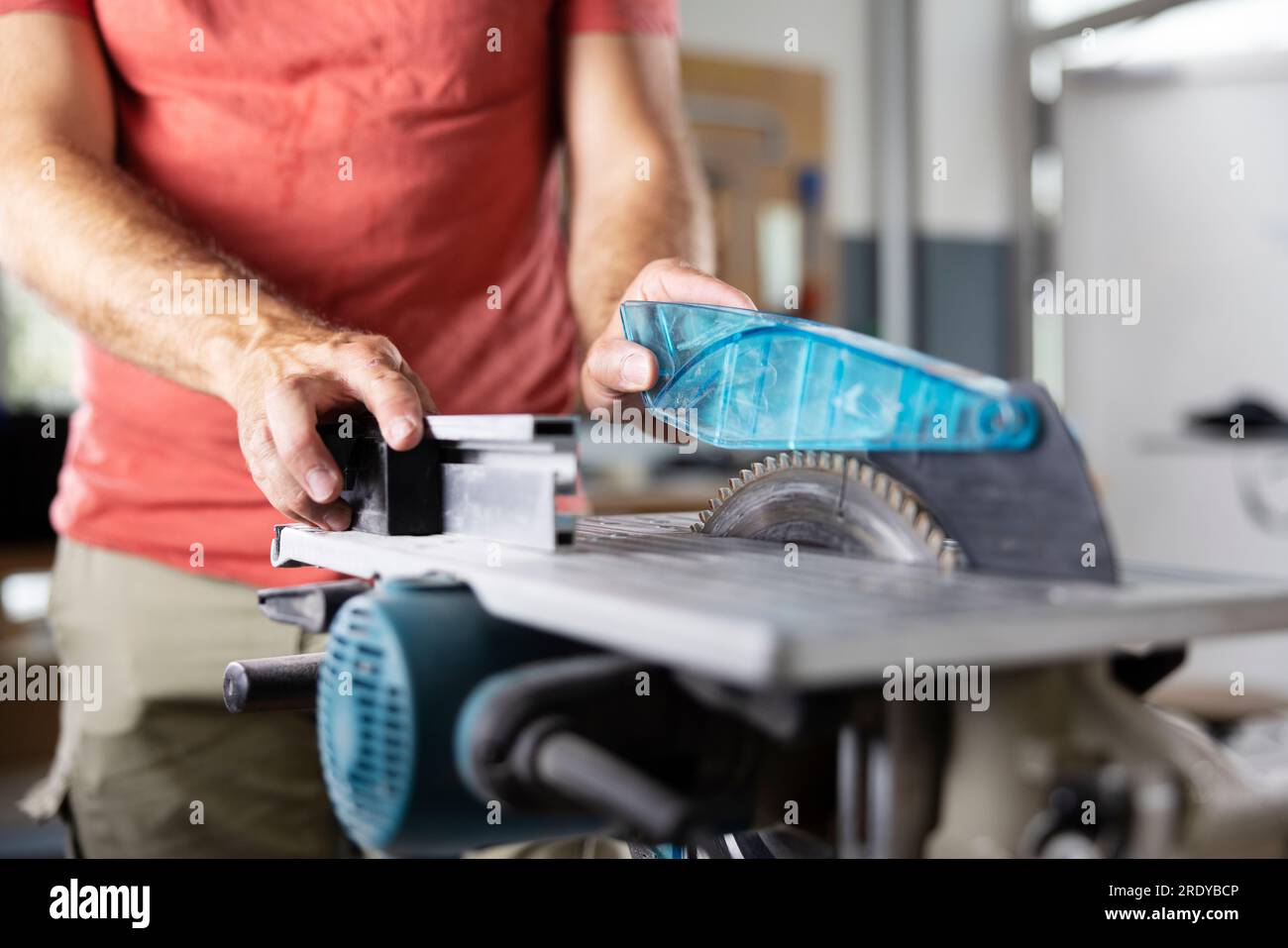Hands of carpenter working on circular saw at workshop Stock Photo
