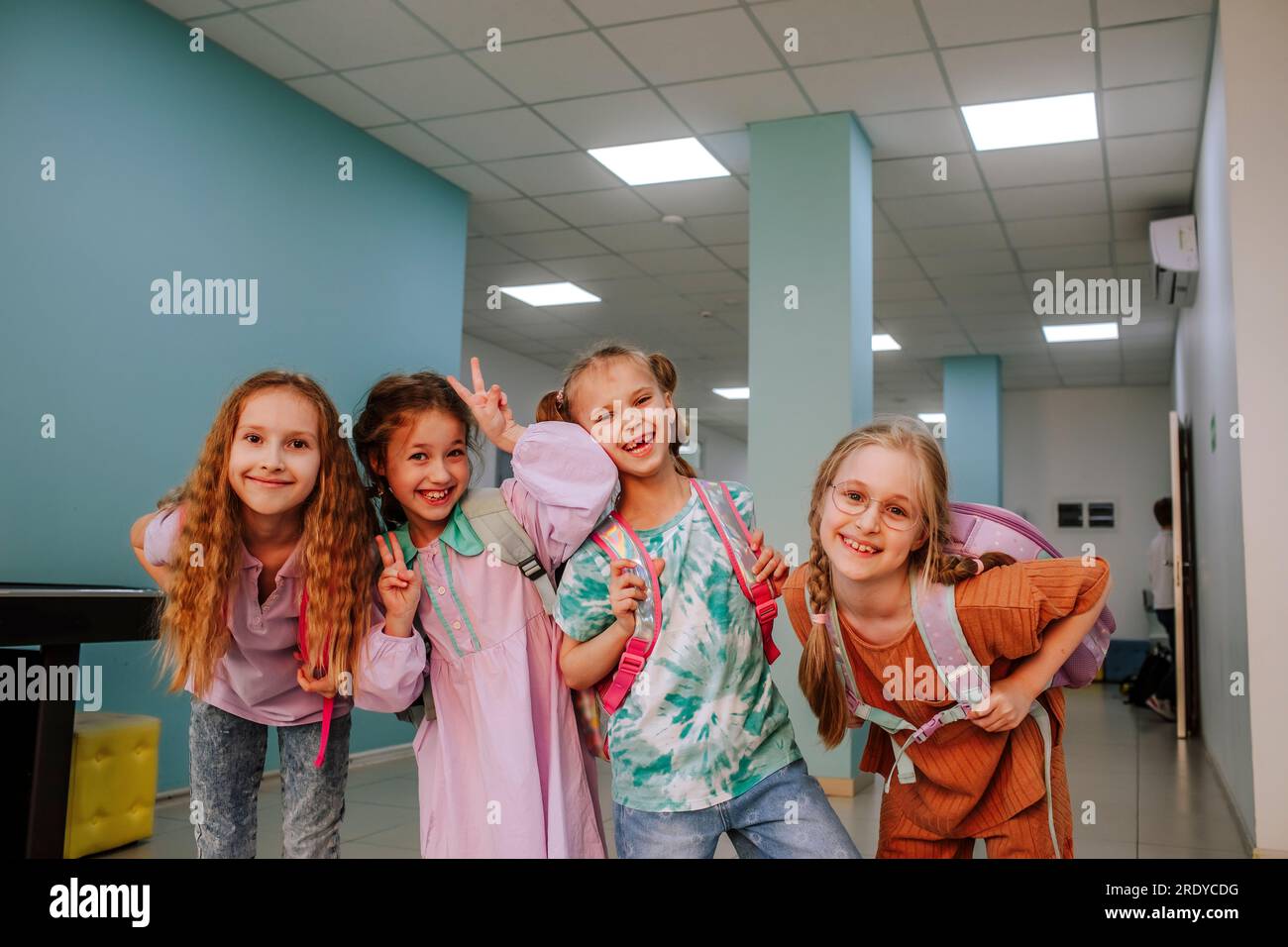 Smiling schoolgirls standing in school corridor Stock Photo - Alamy