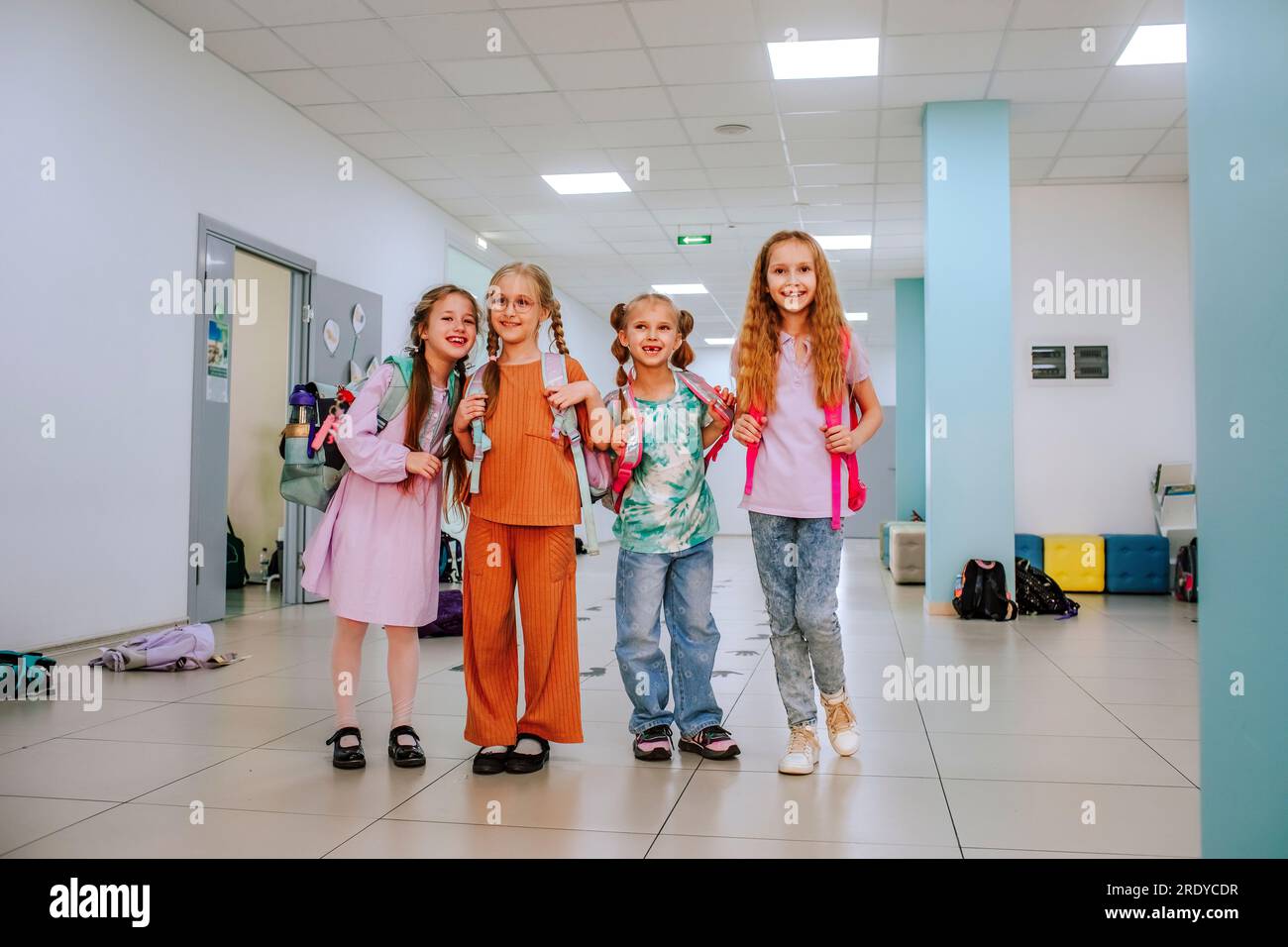 Smiling school students standing together in school corridor Stock Photo