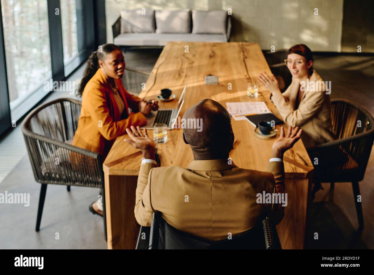 Businessman discussing with coworkers at conference table in convention ...