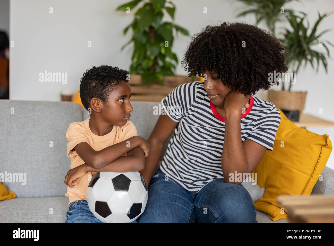 Mother and son spending time together on sofa at home Stock Photo