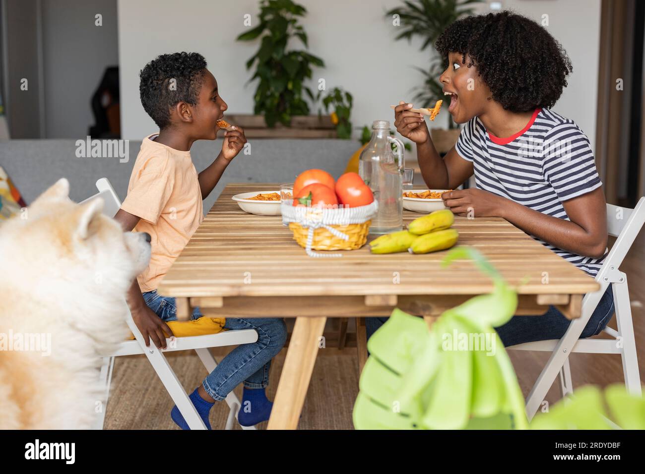 Happy mother and son eating meal together at home Stock Photo