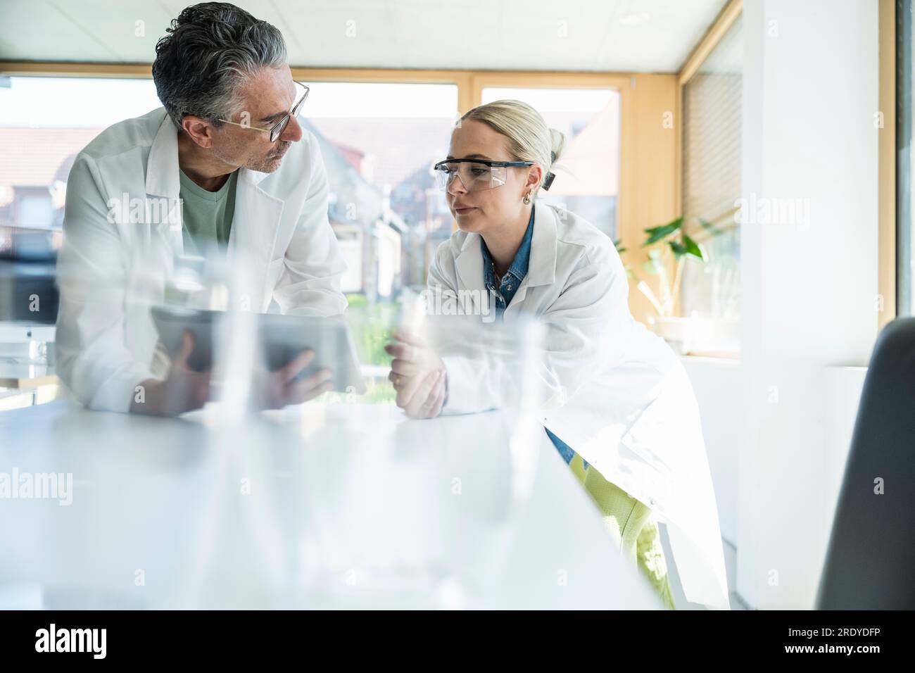 Scientists working on tablet PC in laboratory Stock Photo