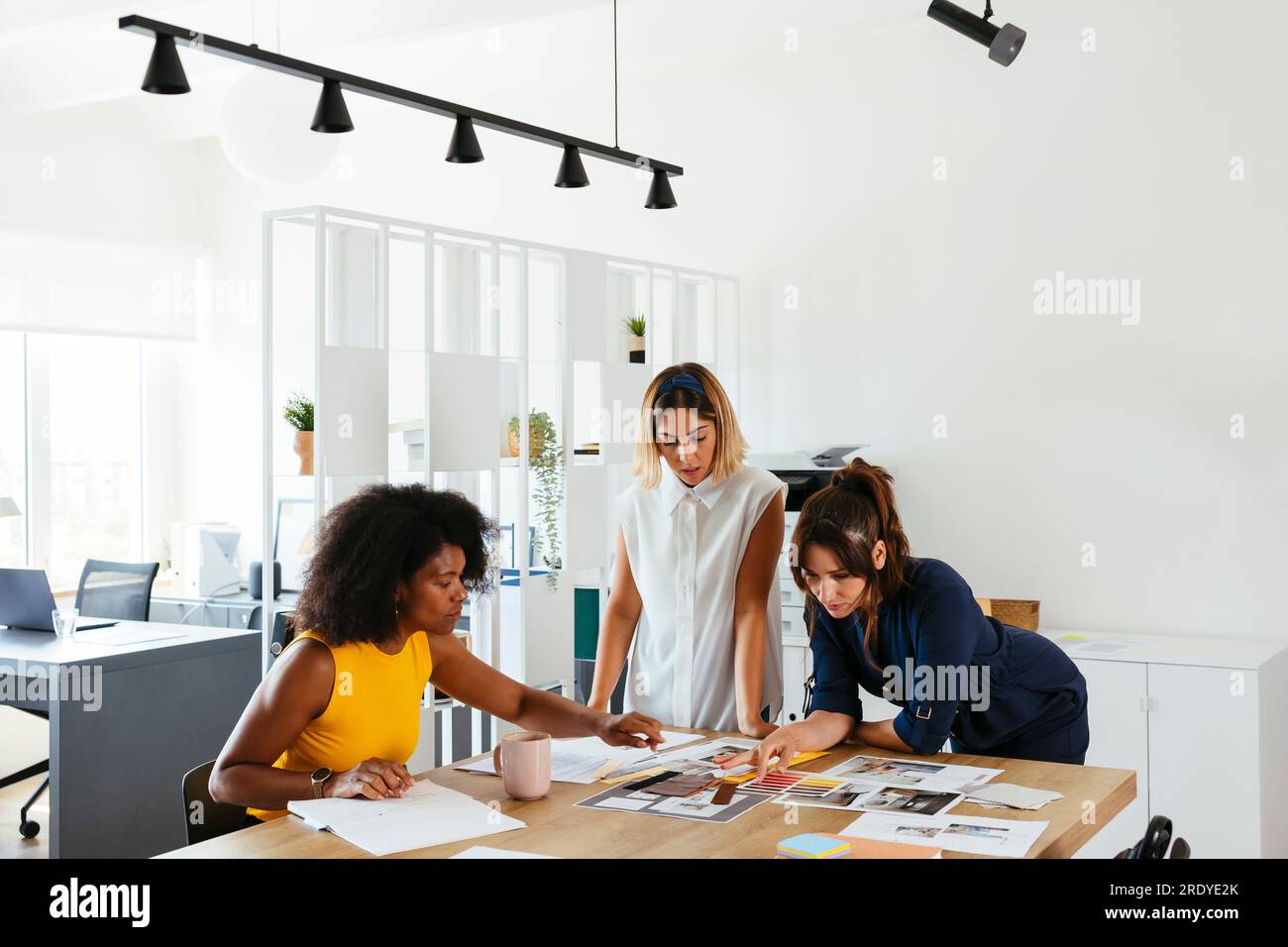 Multiracial business colleagues discussing over documents at creative office Stock Photo