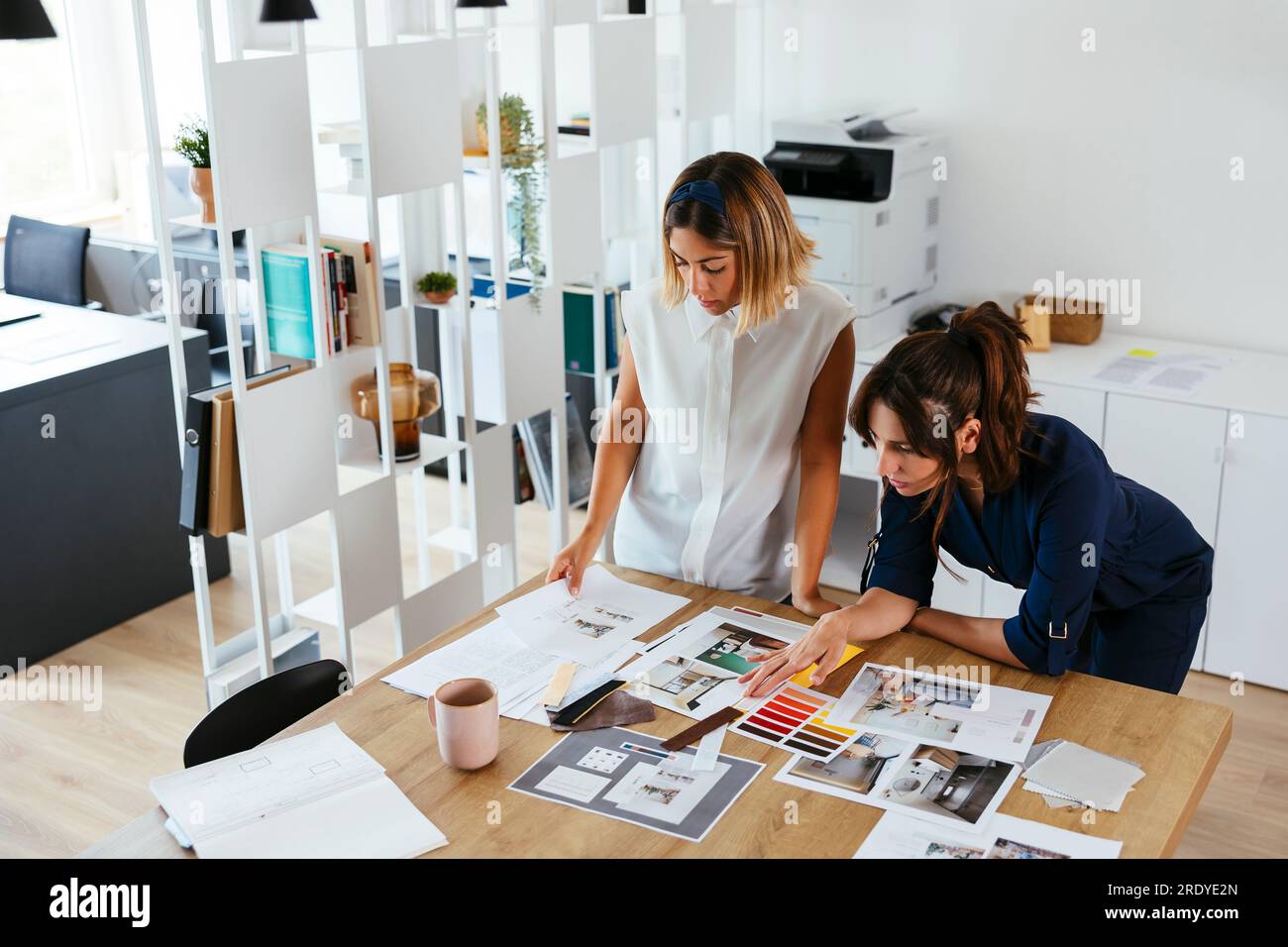 Colleagues discussing over documents at desk in creative office Stock Photo