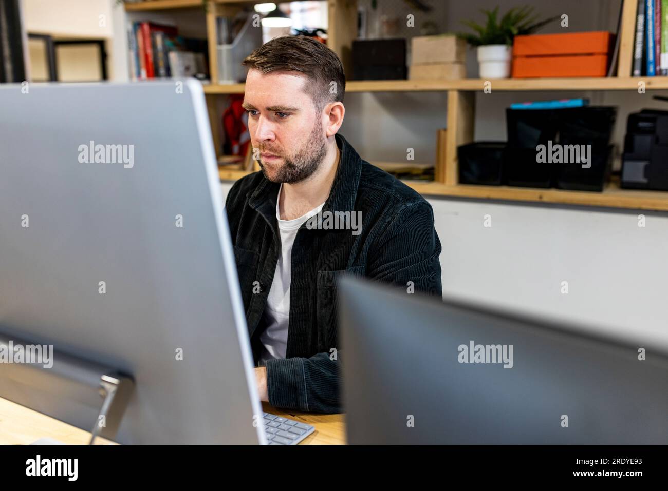 Businessman working on desktop PC in office Stock Photo