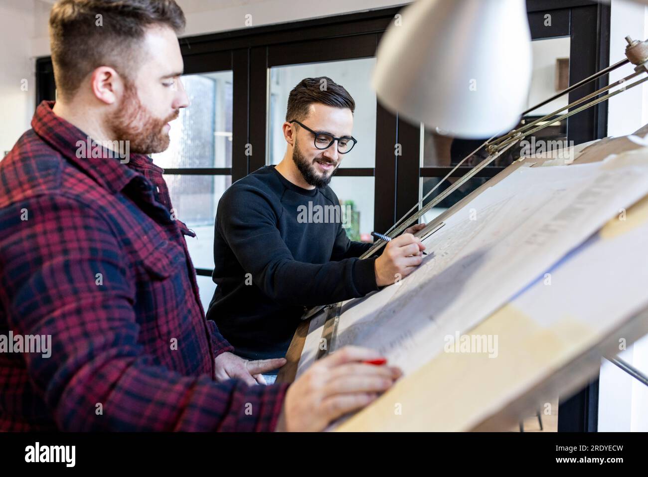 Architects working on blueprint in office Stock Photo