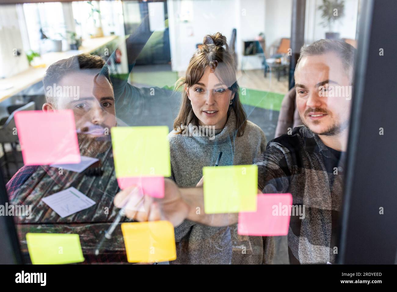 Businessman with colleagues discussing over adhesive notes Stock Photo