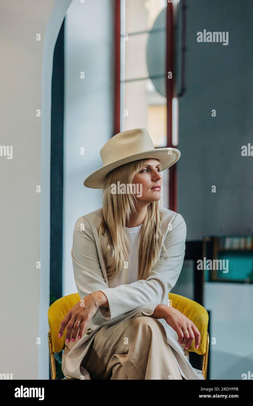 Contemplative woman sitting on chair Stock Photo - Alamy