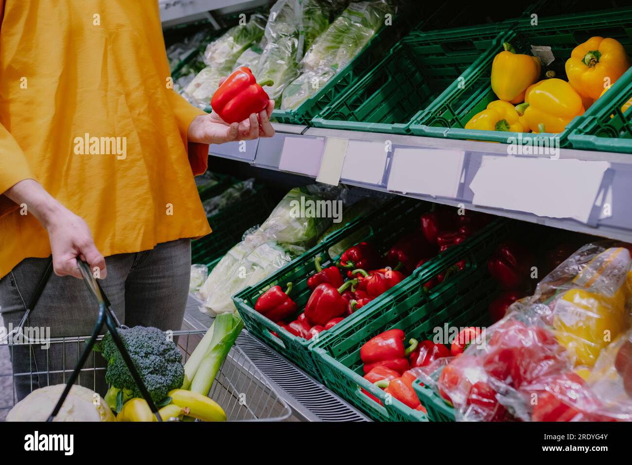 Woman buying red bell pepper at supermarket Stock Photo