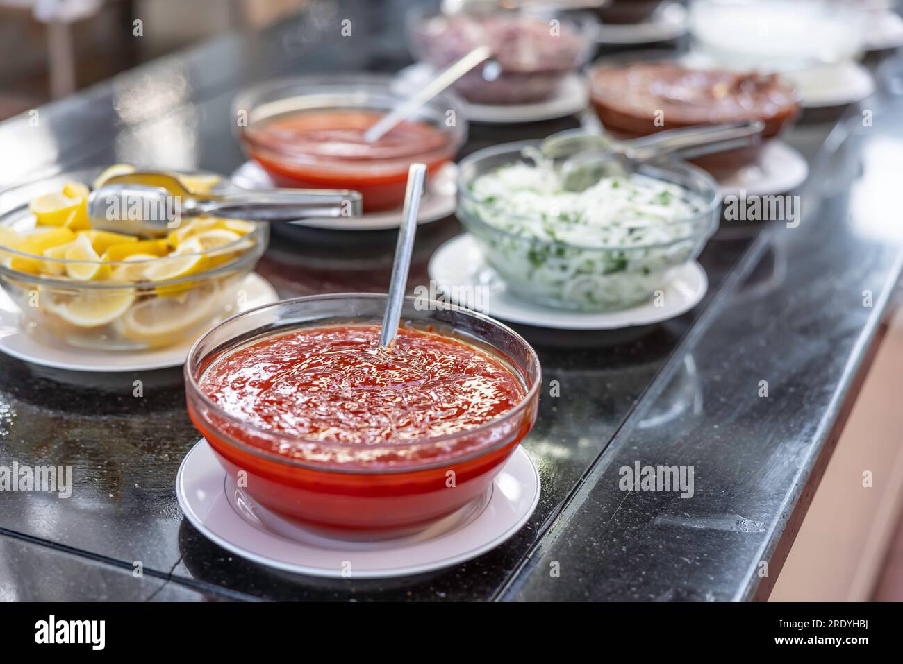 Sweet chili sauce and various dressings on a buffet table in a garden restaurant Stock Photo
