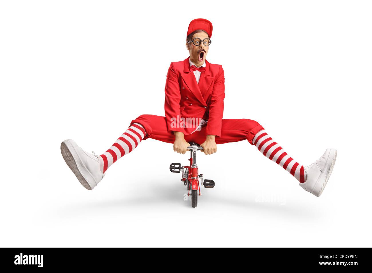 Funny man in a red suit riding a small red bike isolated on white background Stock Photo