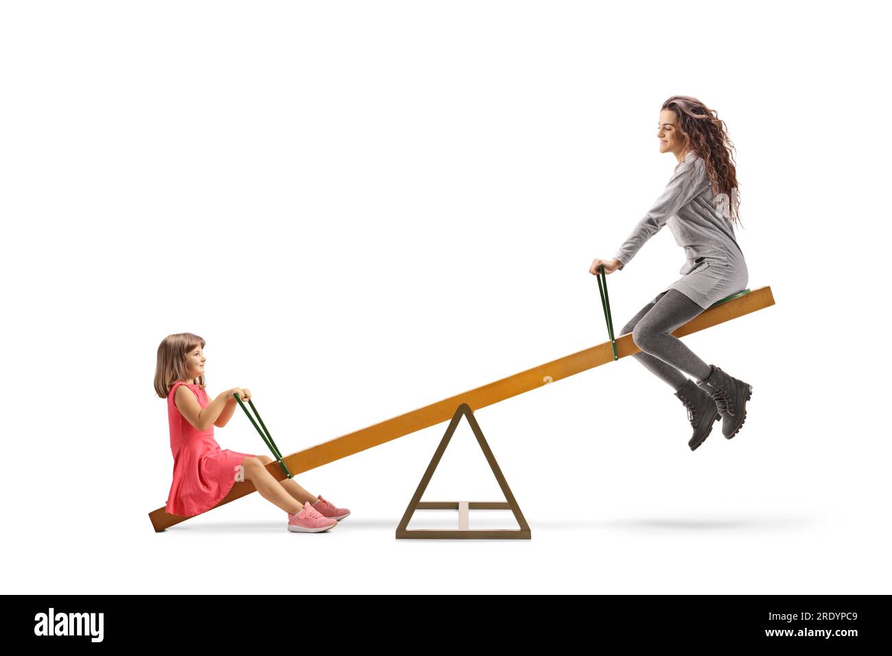 Young woman playing on a seesaw with a child isolated on white background Stock Photo