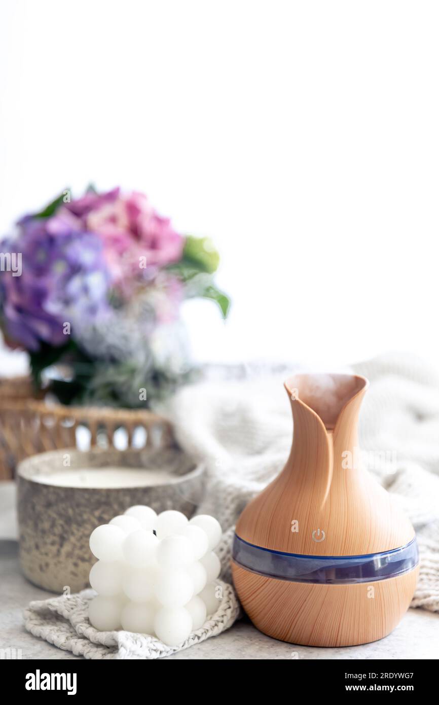 Spa composition with aroma oil diffuser lamp and candle on a blurred background. Stock Photo