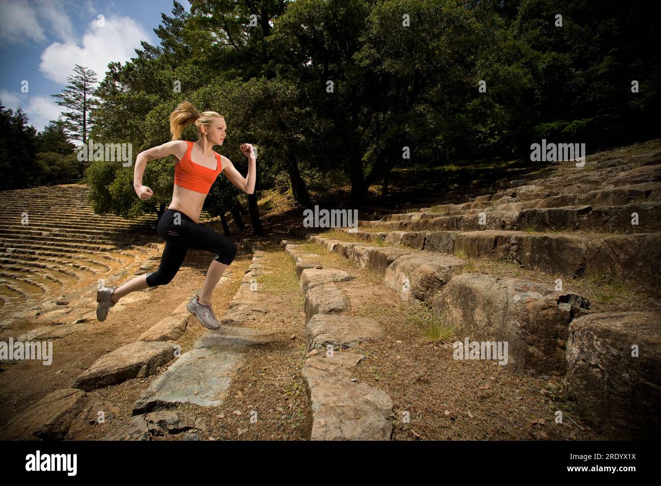 A woman runs up stone steps at an ampitheater in Mt. Tamalpais State Park in Mill Valley, California. Stock Photo