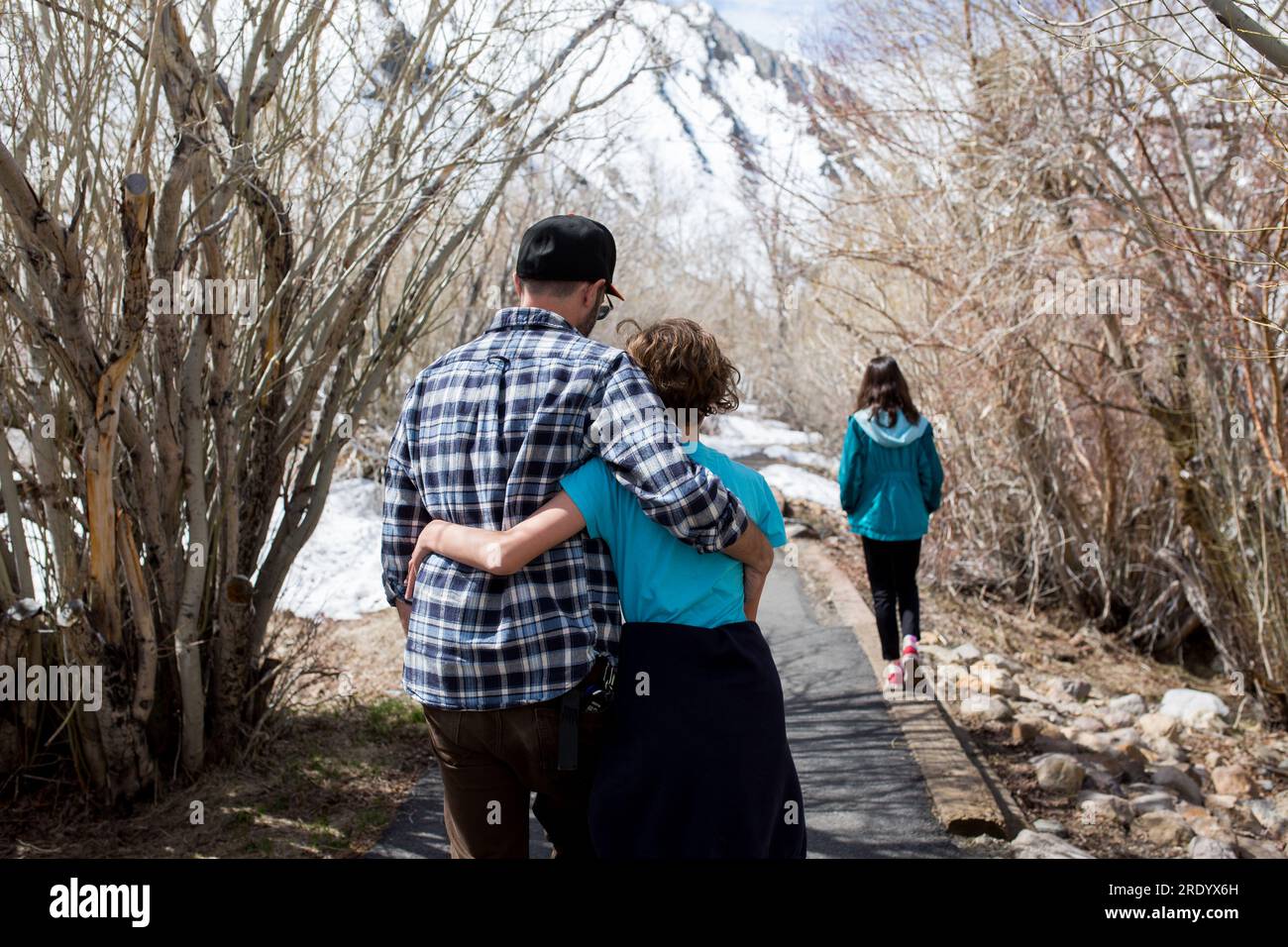 Backside view of father and daughter embracing as they walk in nature Stock Photo