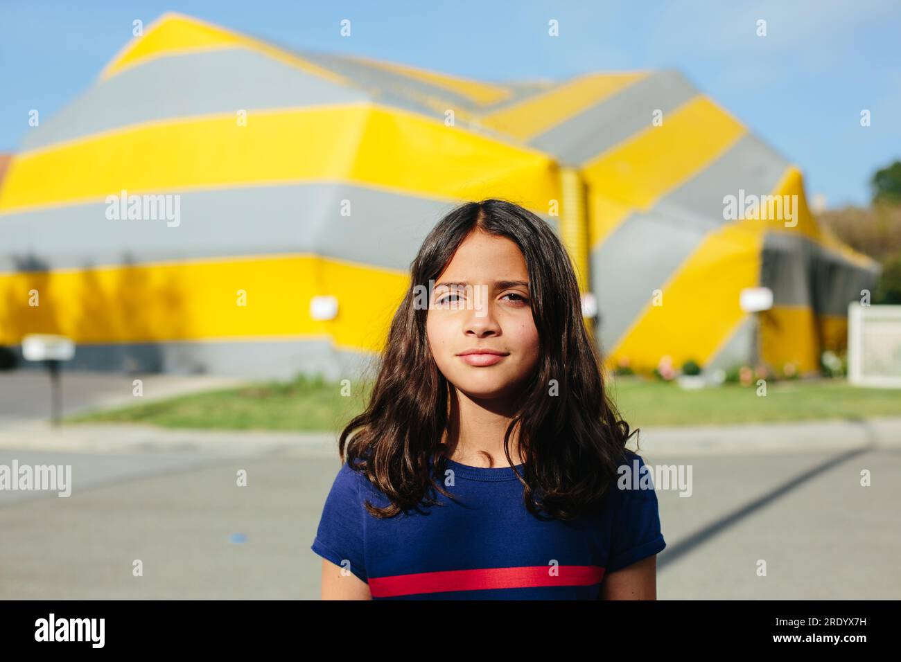 Portrait of a girl outside with a tented house in the background Stock Photo