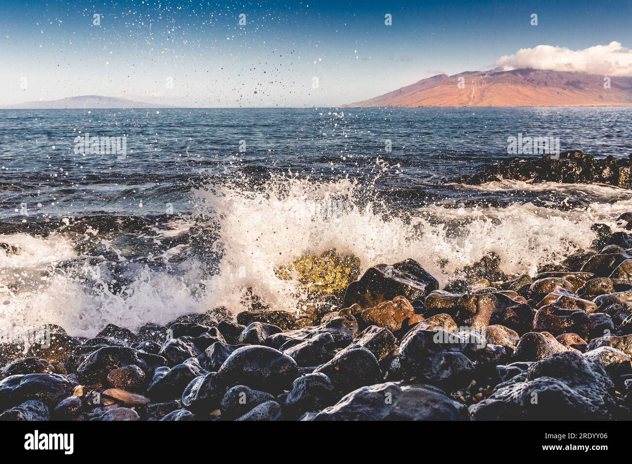 Ocean waves hitting rocks on sunny day in Wailea, Maui Stock Photo