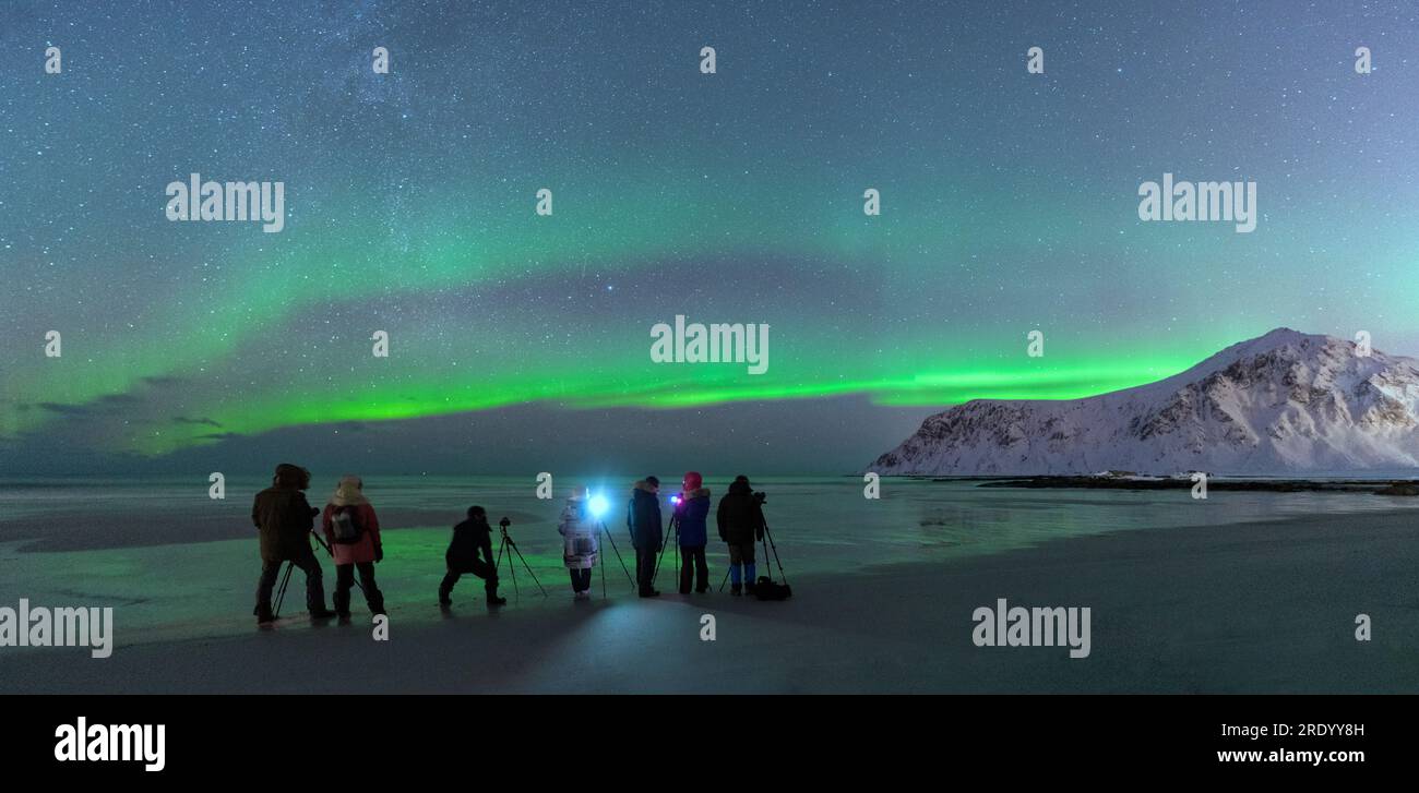 Photographers on Skagsanden beach during Northern Lights, Norway Stock Photo