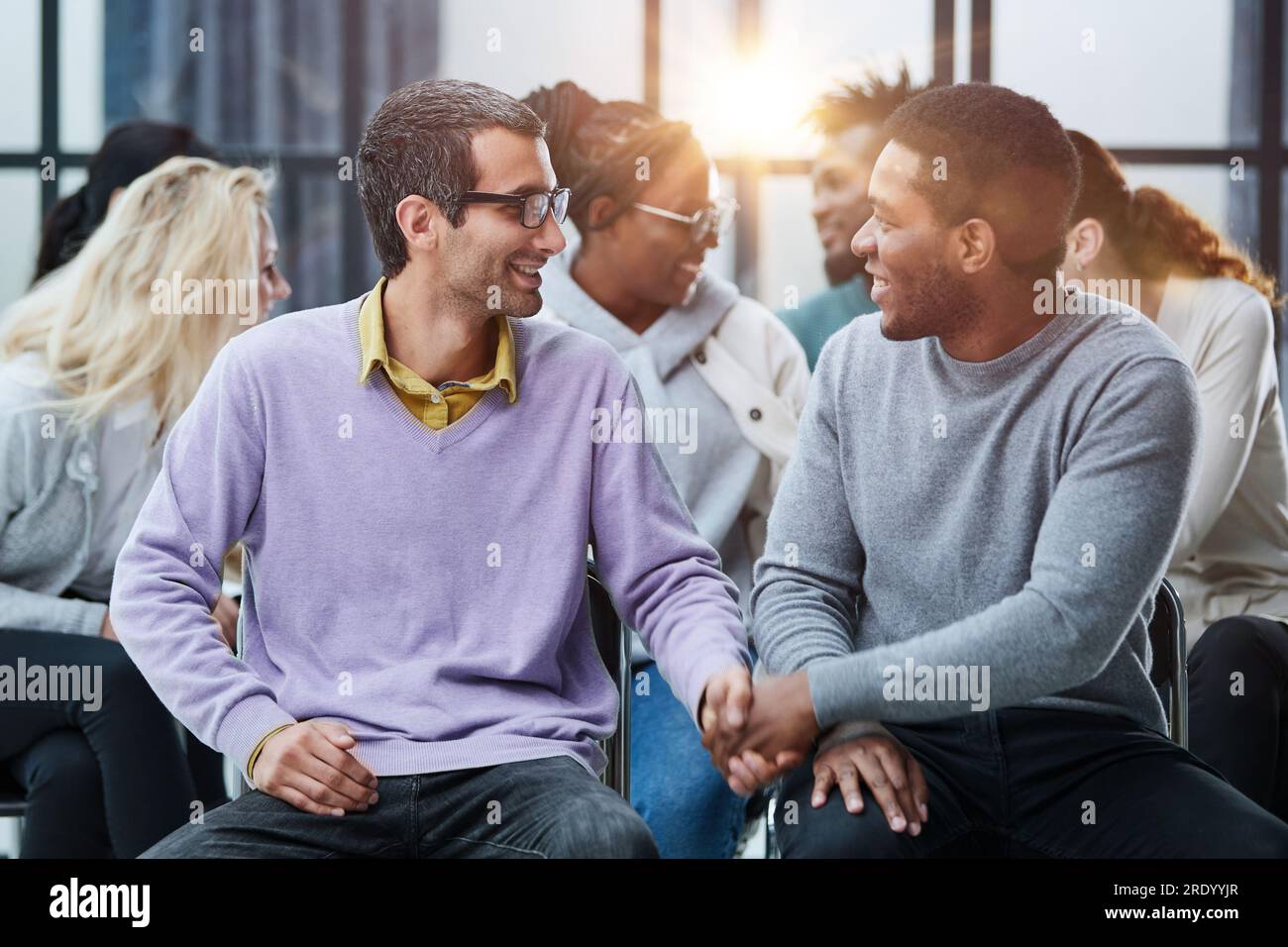 Happy multiethnic employees having fun while discussing project, sharing ideas, informal brainstorming sitting on chairs Stock Photo
