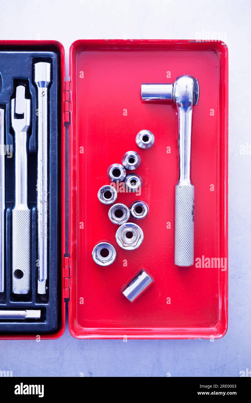 Top view on ratchet drill and socket wrenches in red toolbox Stock