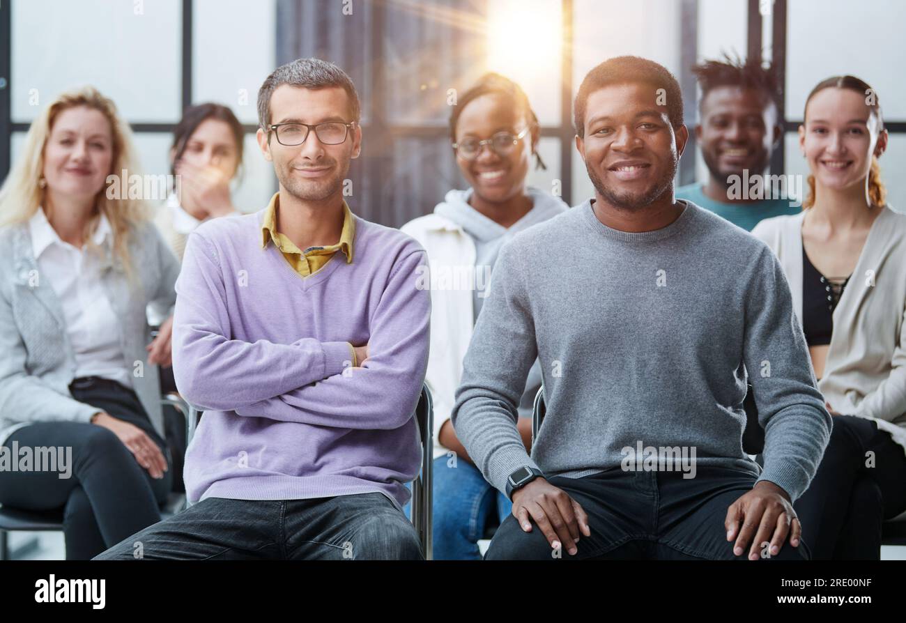 diverse young people sitting on chairs in the conference room Stock ...