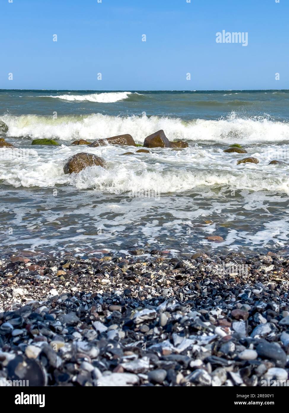 Waves in sea near coastline on empty pebble beach Stock Photo - Alamy