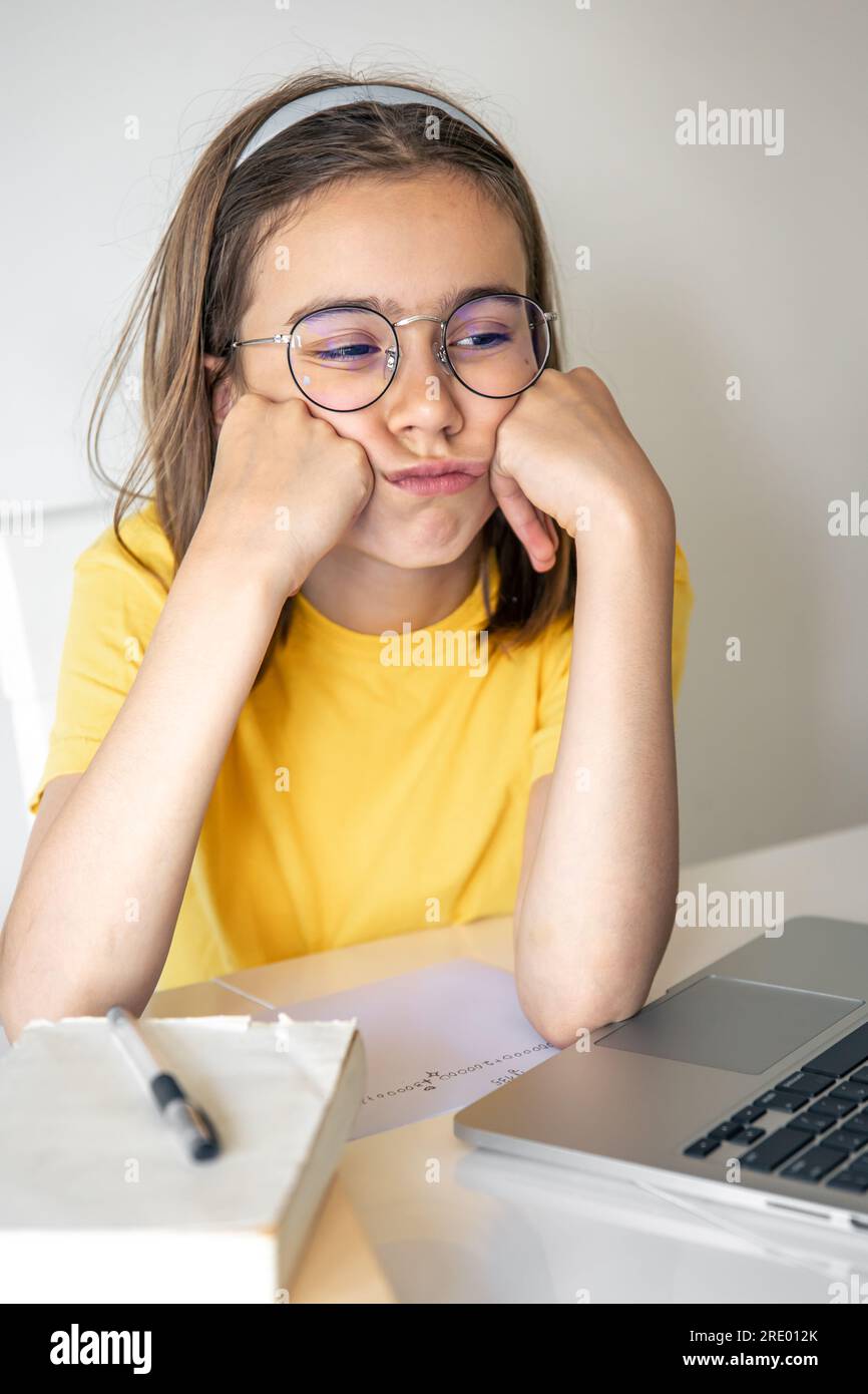 Exhausted schooler girl suffering from doing homework, tired from
