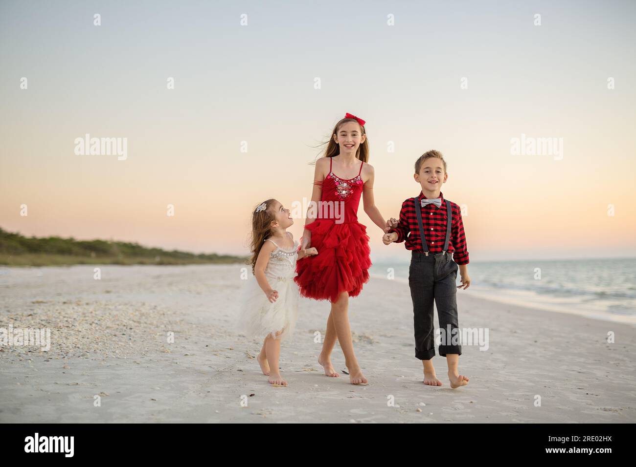 Siblings walking and smiling on the beach at christmas Stock Photo - Alamy