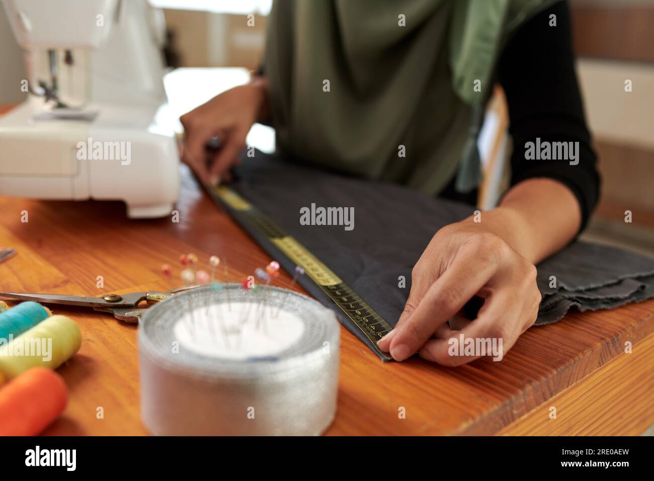 Seamstress using tape measure when working on gown for client Stock