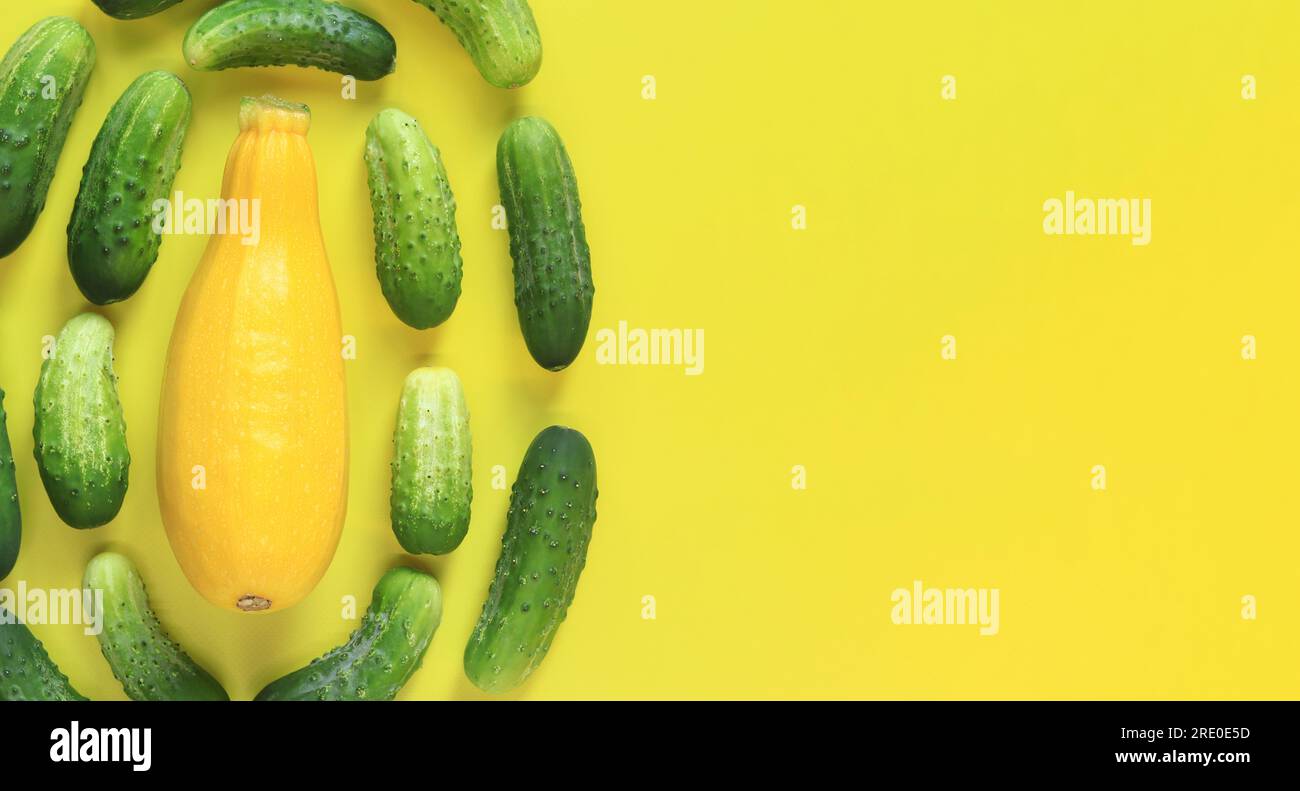 Freshly picked vegetables, zucchini and cucumbers on a yellow background, top view. Place for text Stock Photo