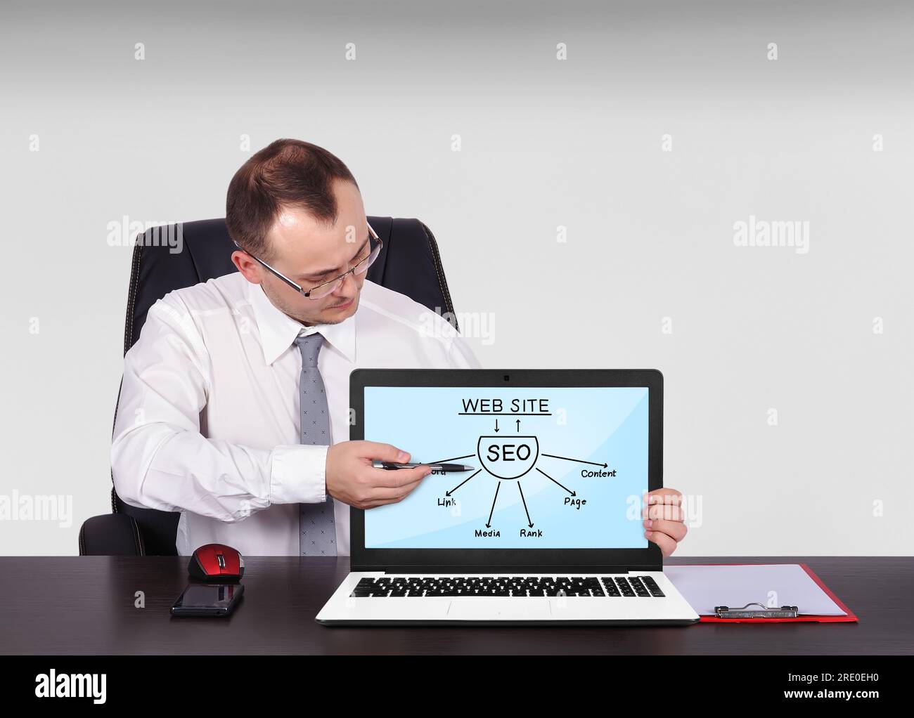 businessman sitting in office and pointing to screen notebook with seo scheme Stock Photo