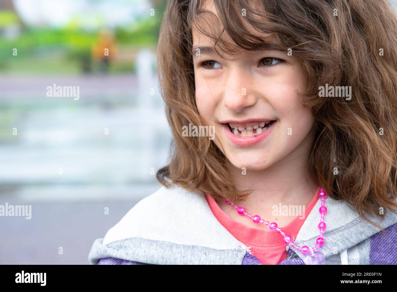 Toothless happy smile of a girl with a fallen lower milk tooth closeup
