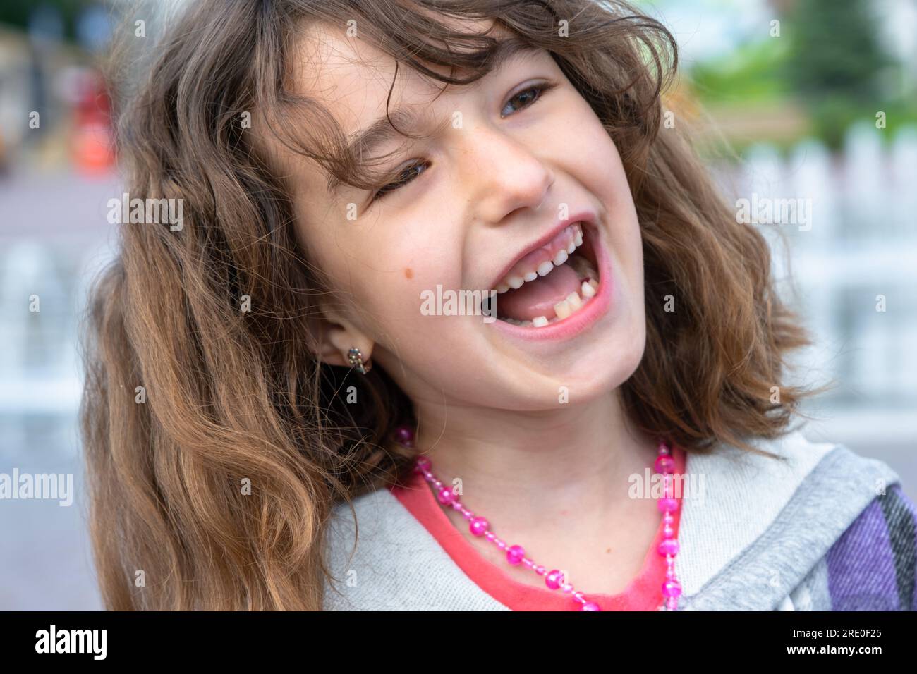 Toothless happy smile of a girl with a fallen lower milk tooth close-up. Changing teeth to molars in childhood Stock Photo