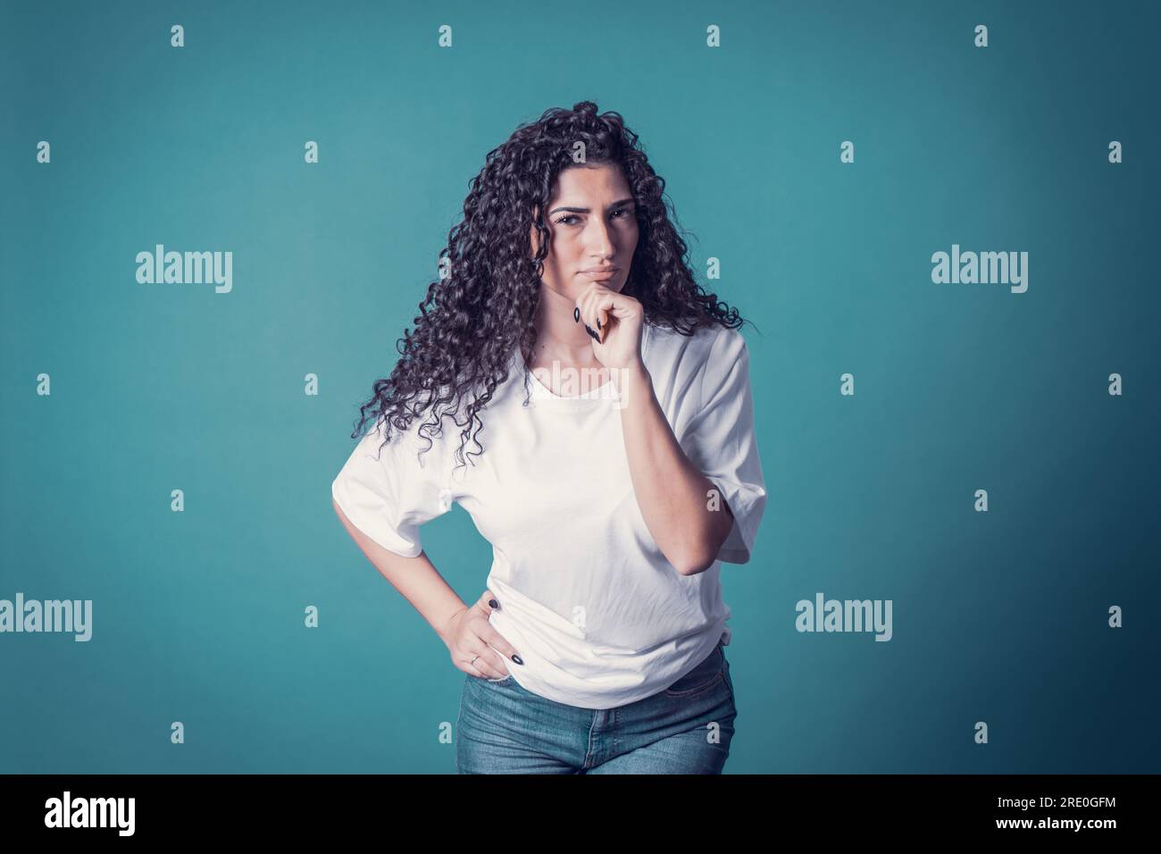 Shot of serious confident curly woman, wears casual basic solid Stock Photo